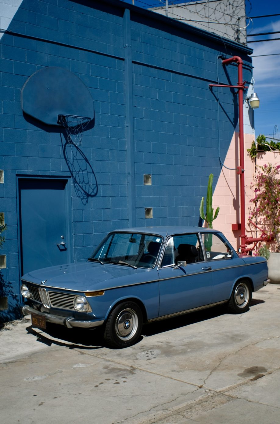 A blue BMW 2002 parked on a Los Angeles side street